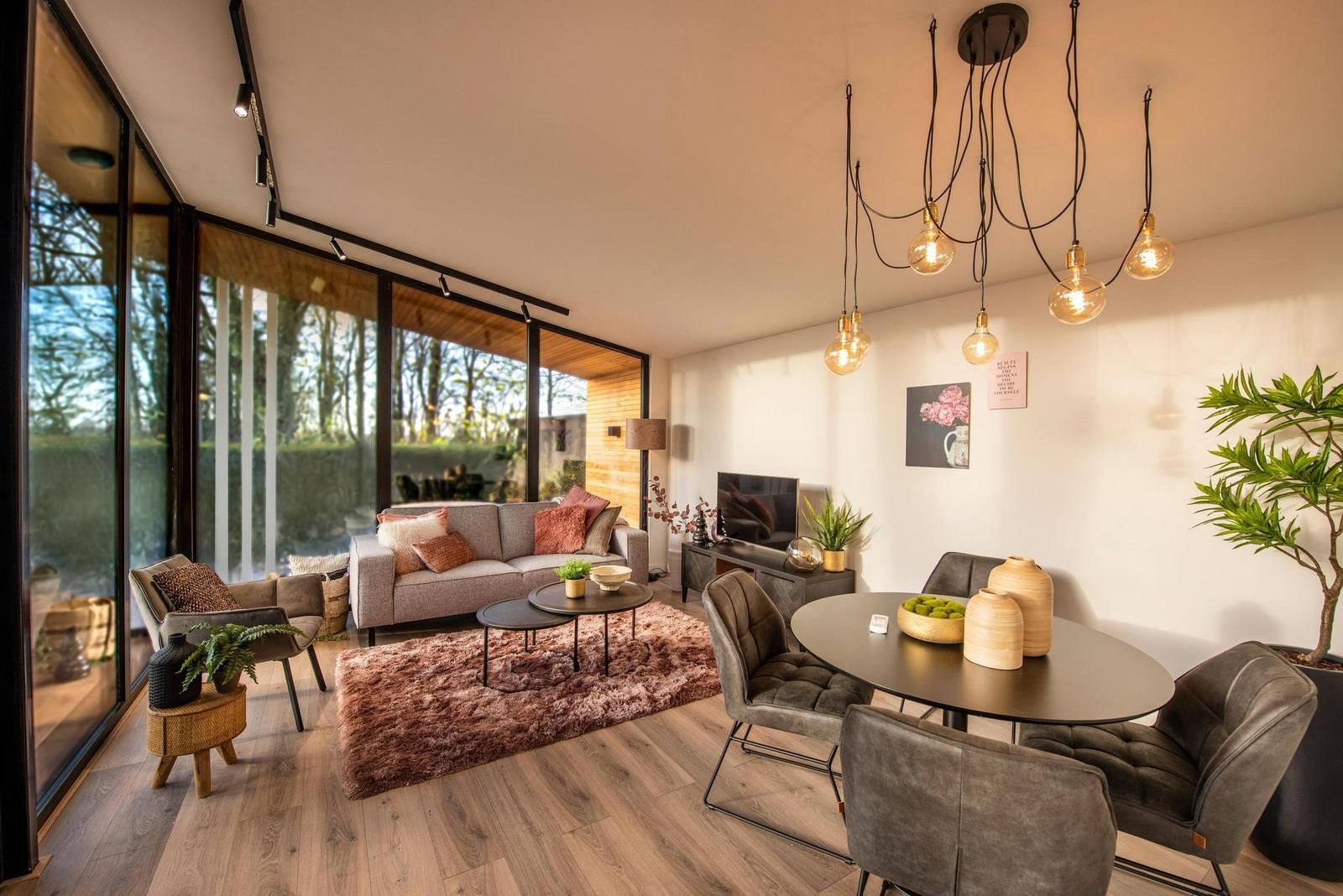 Gemuetliches Wohnzimmer von Bos Cottage mit Sauna und Whirlpool in Maasbree, Nord-Limburg. Ferienhaus mit moderner Einrichtung und Blick auf die Natur.