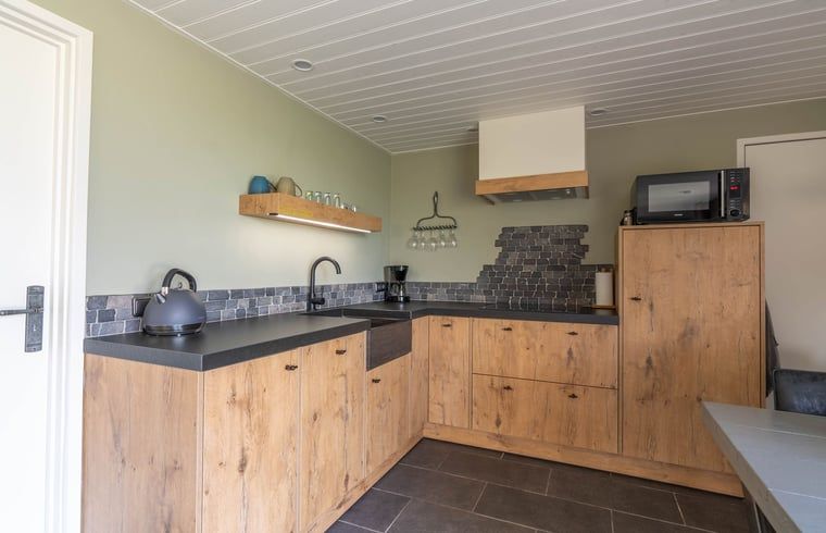 Ecke des Wohnzimmers in Cottage in Merselo, Ferienhaus in Nord-Limburg mit Fernseher.