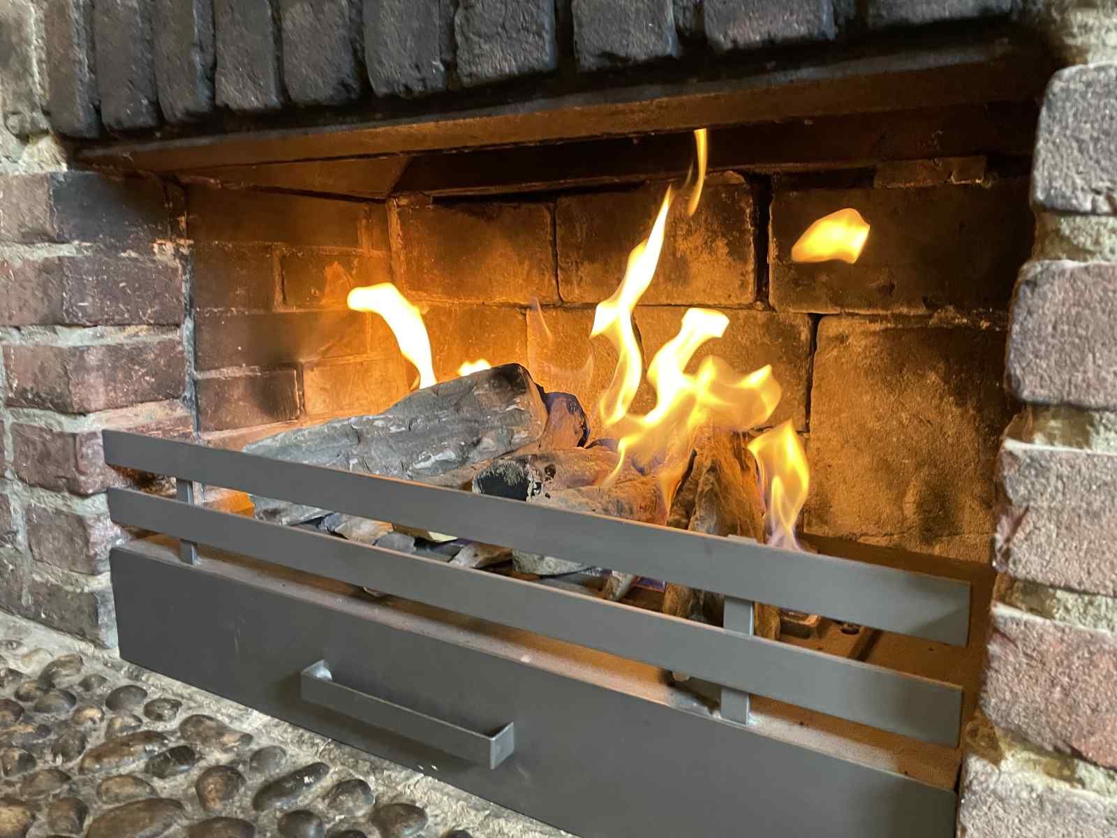 Cozy living room with fireplace in vacation home L243 in Mechelen, South Limburg.