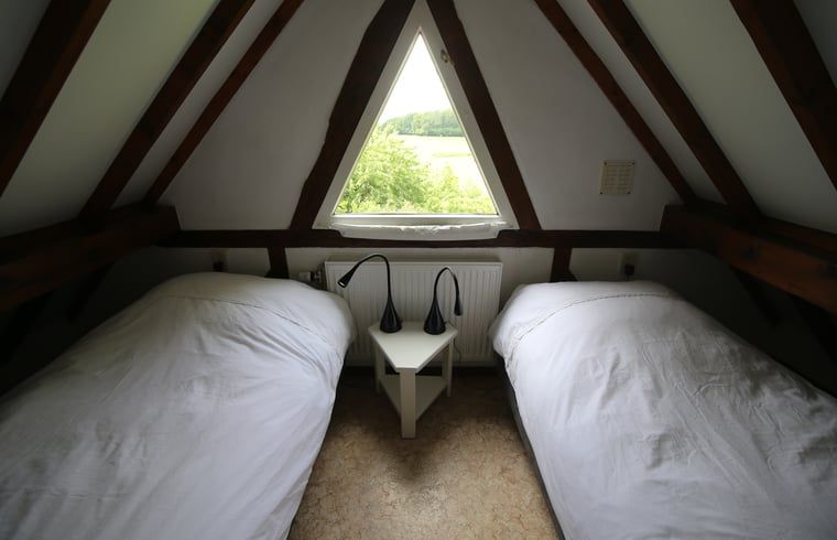Knusse slaapkamer met uitzicht in Vakantiehuisje in Schin op Geul, Zuid Limburg.