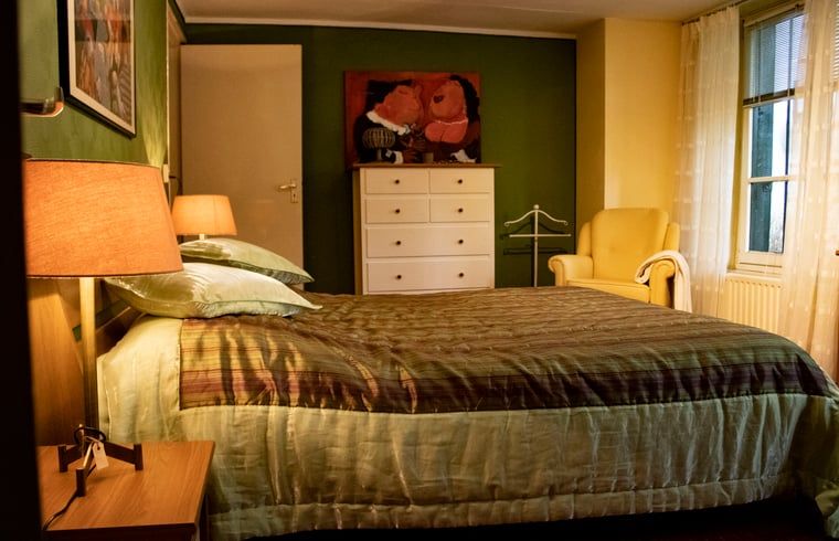 Attractive bedroom with warm lighting in Cottage in Valkenburg, vacation home in South Limburg.