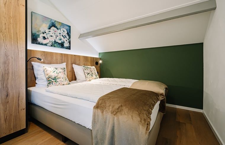 Knusse slaapkamer met kunst aan de muur in Vakantiehuis in Gulpen, Zuid Limburg.