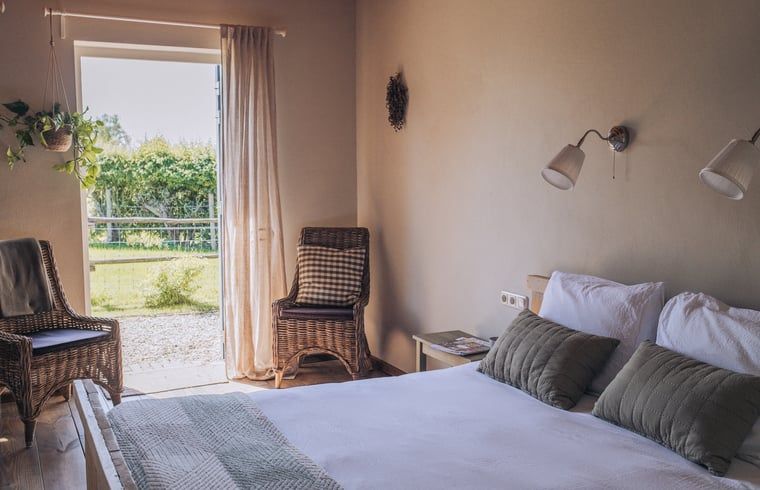 Slaapkamer met uitzicht op tuin in Huisje in Slenaken vakantiehuis in Limburg.