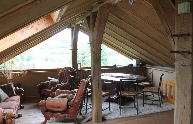 Cozy interior of Holiday Home in Vijlen, South Limburg, with wooden beams and views of beautiful nature.