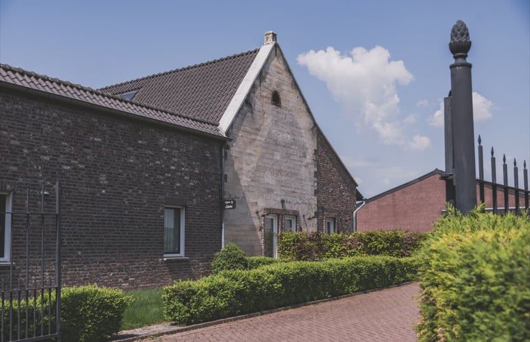 Vakantiehuis in Scheulder, Zuid Limburg, met charmante stenen gevel en groene heg.