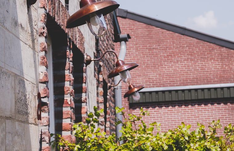 Koperen buitenlampen sieren het vakantiehuis in Scheulder, Zuid Limburg.