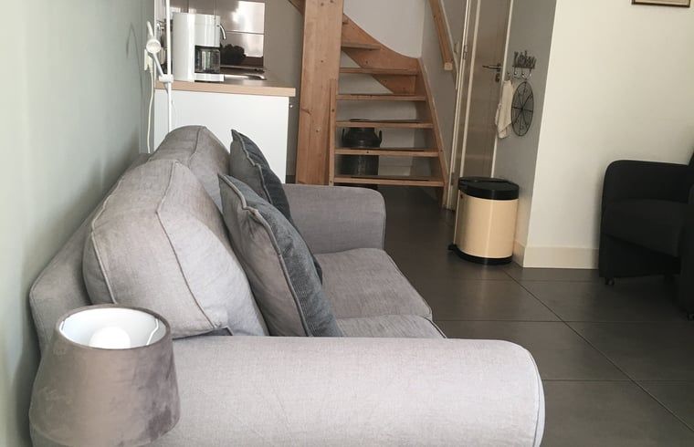 Gezellige woonkamer met trap in Vakantiehuis in Scheulder, Zuid Limburg.