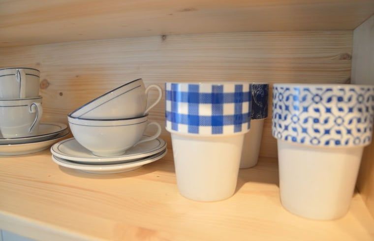 Stijlvol servies in open kast van Vakantiehuis in Scheulder, Zuid Limburg.