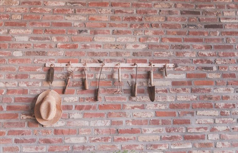 Landelijke muurdecoratie met tuingereedschap in Vakantiehuis in Scheulder, Zuid Limburg.