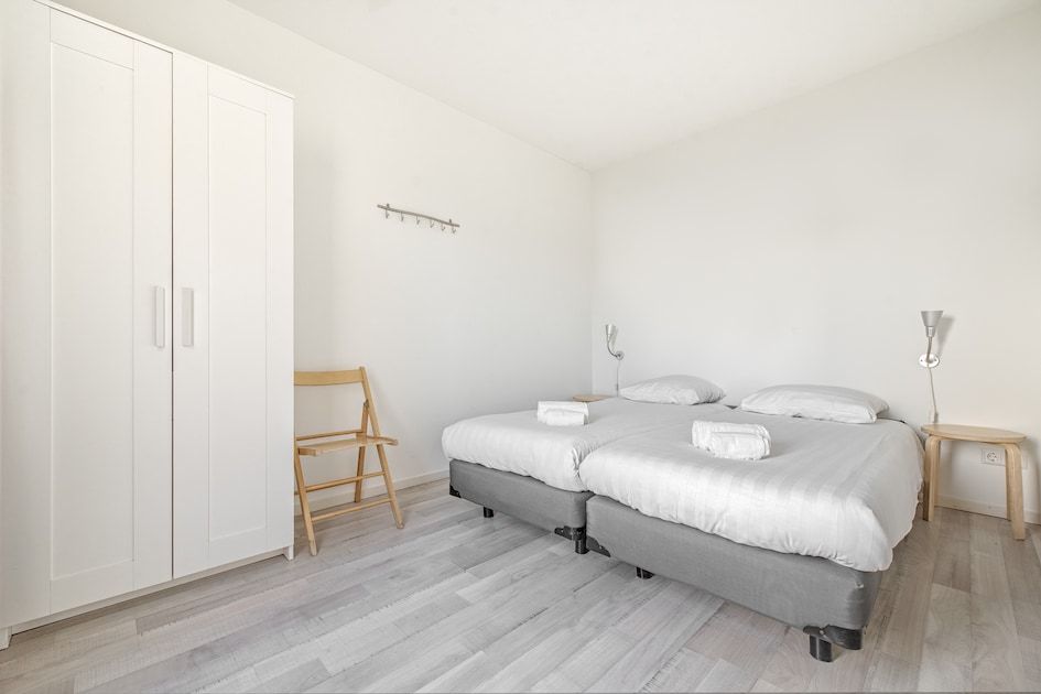 Sfeervolle slaapkamer in bungalow Anemoon 12, Walem, Zuid Limburg, met comfortabel tweepersoonsbed en natuurlijk lichtinval.