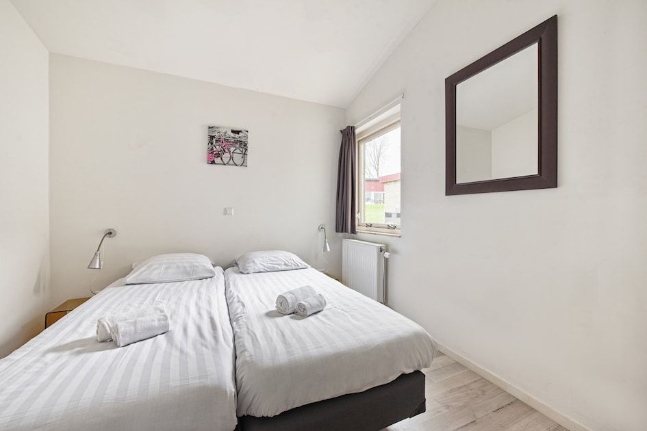Slaapkamer in Anemoon 12 bungalow, Walem, Zuid Limburg, met twee comfortabele bedden en veel natuurlijk licht.