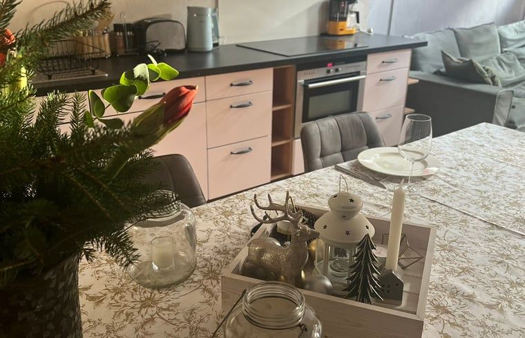 Cozy dining room in vacation home in Beutenaken, South Limburg, with attractive decorations and modern kitchen facilities.