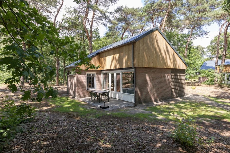 Bungalow 4 in Vlierden, De Peel, Noord Brabant, omgeven door bosrijke natuur met een gezellig terras voor een ontspannen verblijf.