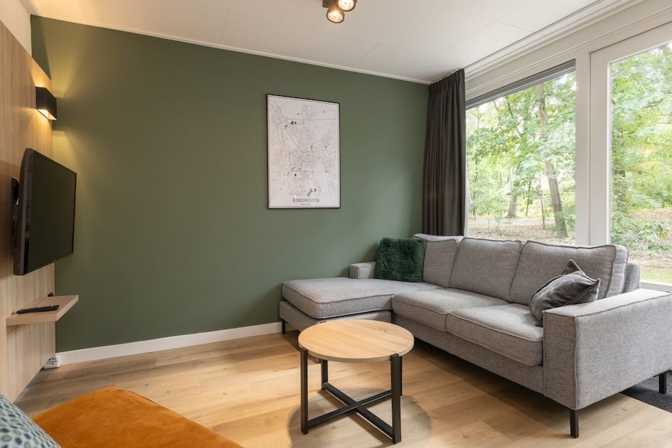 Gezellige woonkamer in Bungalow 4, vakantiehuis in Vlierden, De Peel, Noord Brabant met comfortabele zithoek en uitzicht op de natuur.