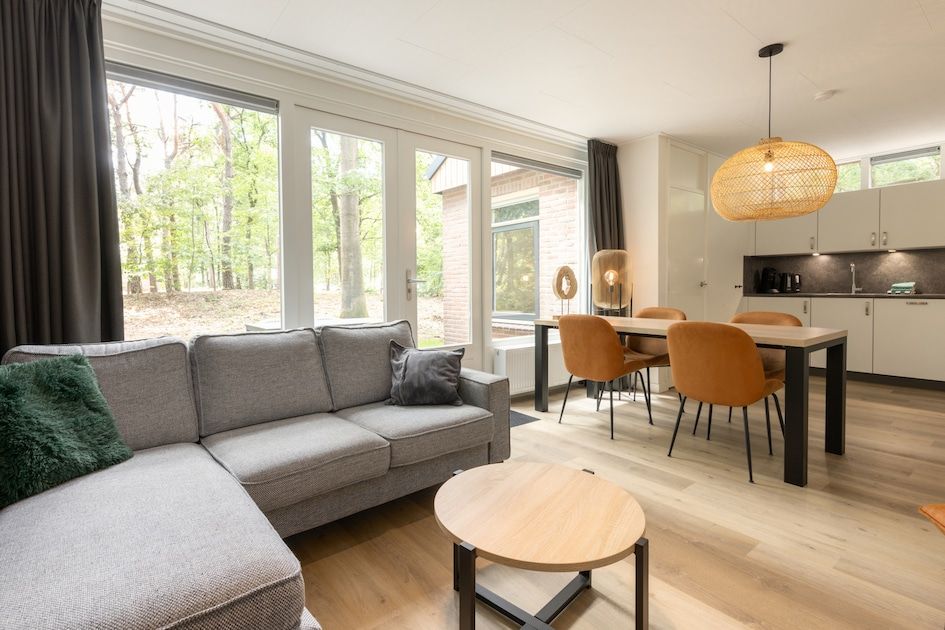 Gezellige woonkamer van Bungalow 4 in Vlierden, De Peel, Noord Brabant met uitzicht op de groene natuur vanuit de comfortabele zithoek.