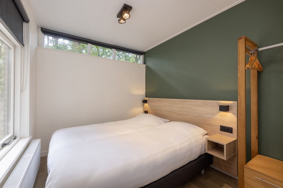 Slaapkamer in Bungalow 4, Vlierden, De Peel, Noord Brabant met comfortabel tweepersoonsbed en uitzicht op de omringende natuur.