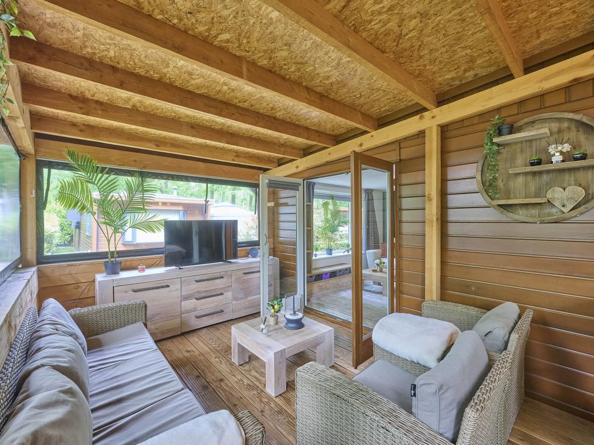 Gezellige binnenruimte van vakantiehuis 't Heische hofje in Zeeland, De Peel, Noord Brabant, met comfortabele zitplek en uitzicht op de natuur.