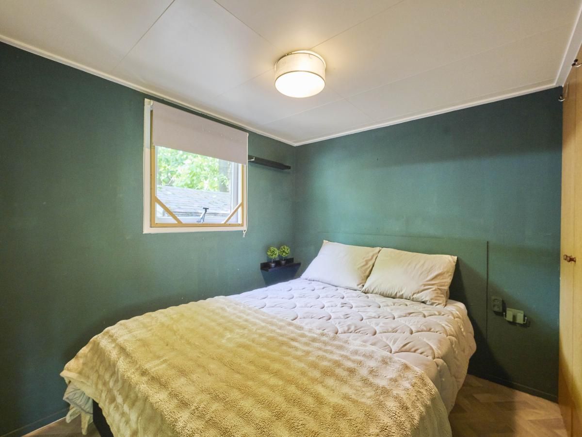 Gezellige slaapkamer in 't Heische hofje, vakantiehuis in Zeeland, De Peel, Noord Brabant, met comfortabel bed en uitzicht op de natuur.