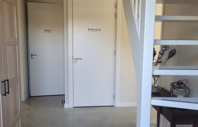 Entrance with stairs to upstairs in Huisje in Zeeland, a charming vacation home in De Peel, North Brabant.