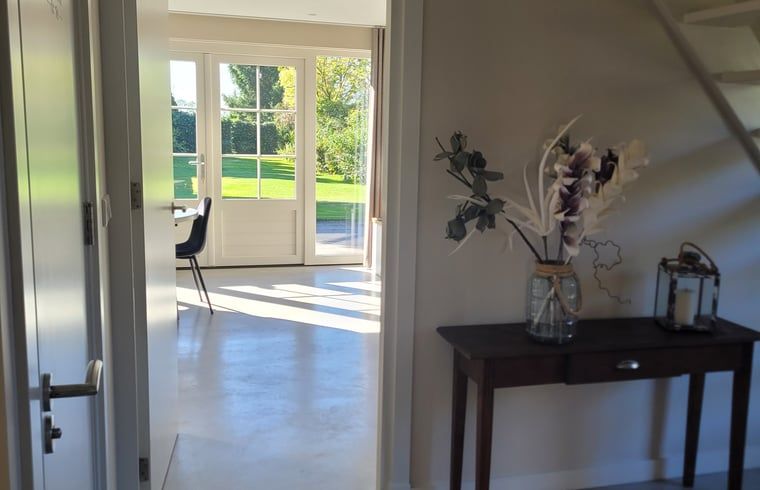 Bedroom with clothes rack and mirror in Huisje in Zeeland, a cozy vacation home in De Peel, North Brabant.