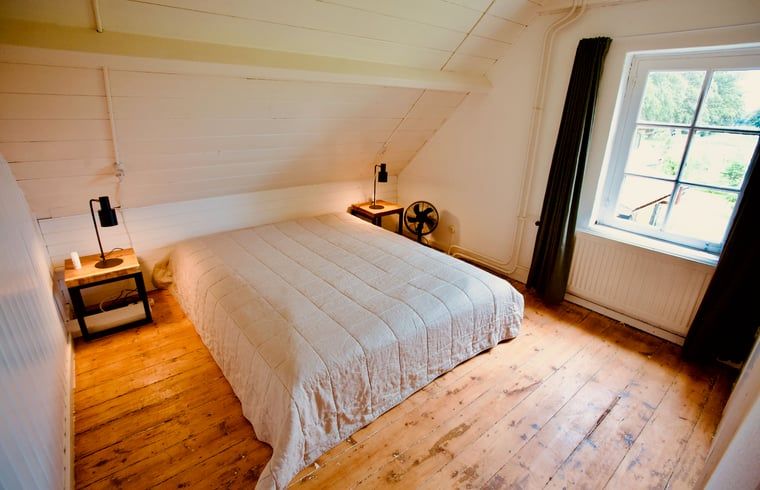 Comfortabele slaapkamer in Vakantiehuis in De Rips, Noord Brabant, met houten vloer.