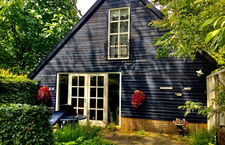 Charmant Vakantiehuis in Budel met blauwe gevel en groene tuin in Kempen, Noord Brabant.