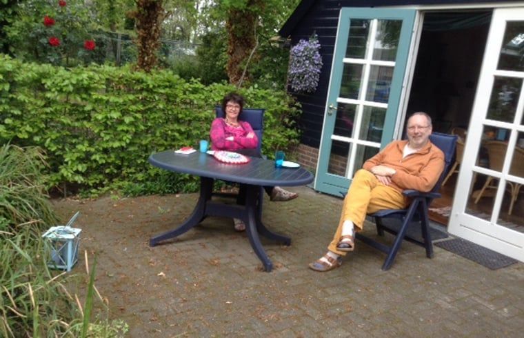 Gasten genieten van de veranda bij Vakantiehuis in Budel, gezellig verblijf in Kempen, Noord Brabant.