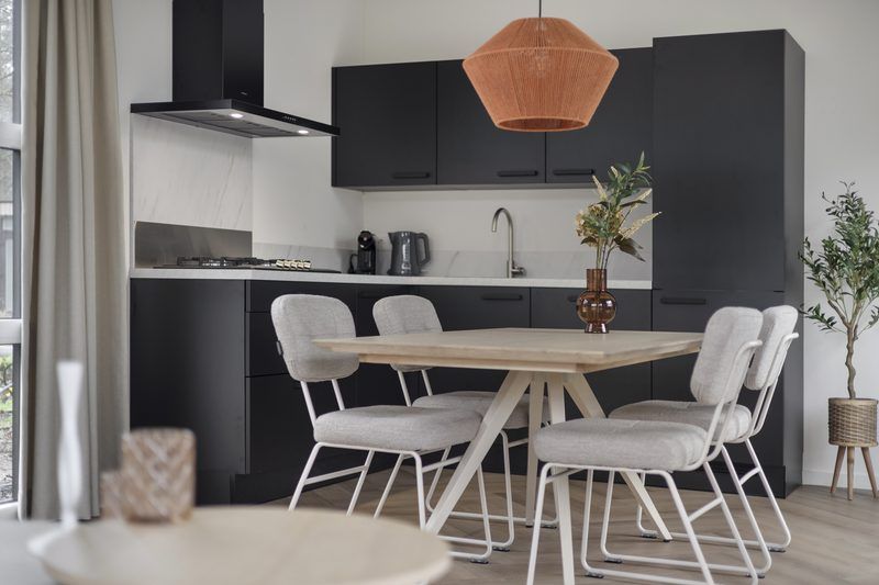 Open kitchen and dining area in Bosvlucht 6 people Wellness vacation home, Lage Mierde, with modern furnishings.