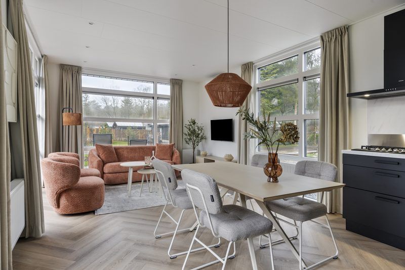 Cozy living room with large windows in Bosvlucht 6 persons Wellness vacation home, Lage Mierde, surrounded by nature.