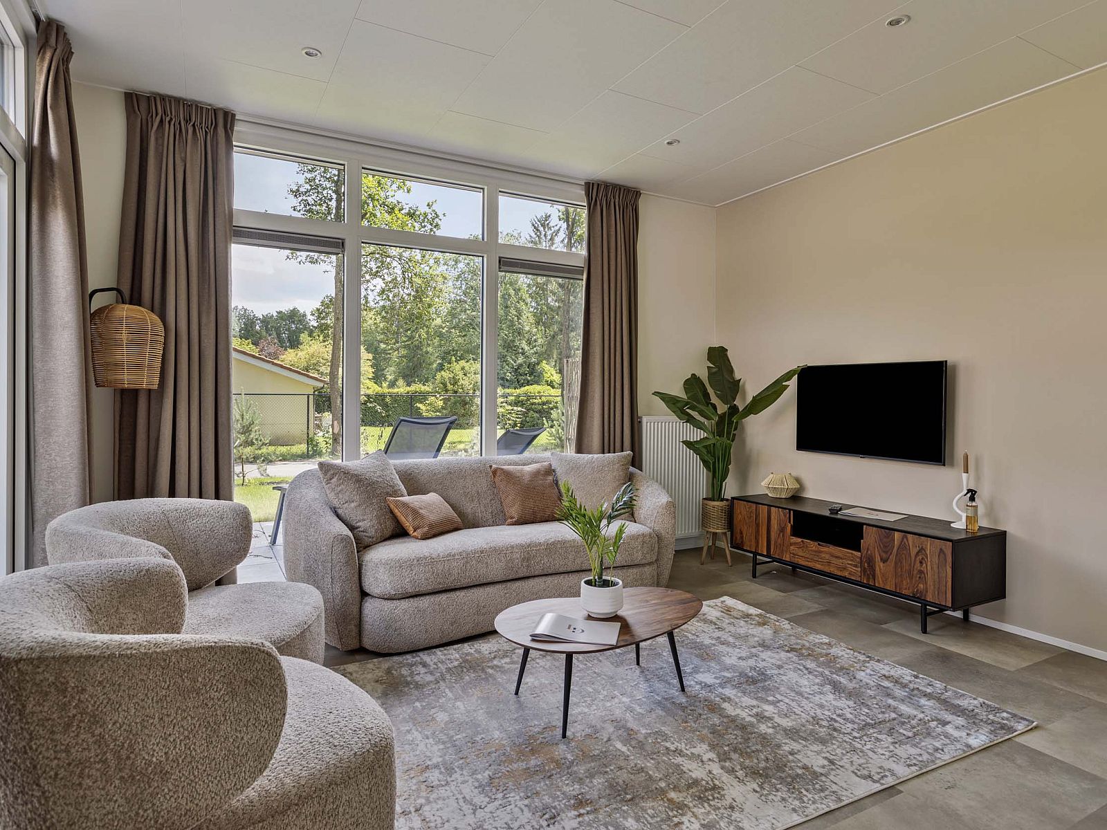 Cozy living room in vacation home Berkenhof with hot tub, located in Lage Mierde, Kempen, North Brabant, overlooking green garden.