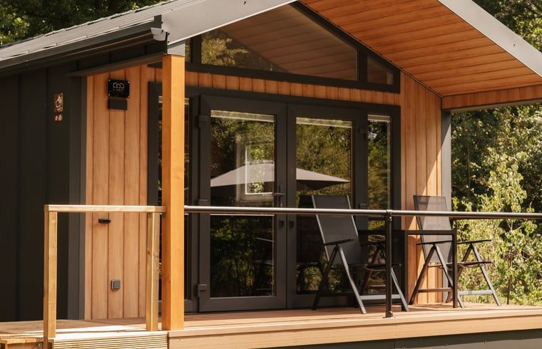 Geniessen Sie die Ruhe auf der Veranda von Huisje in Bergeijk, einem stimmungsvollen Ferienhaus im gruenen Kempen, Nordbrabant.