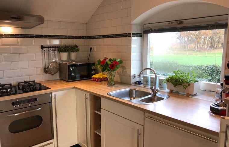 Moderne keuken in Huisje in Baarle-Nassau, vakantiewoning in Kempen, met uitzicht op de groene velden.