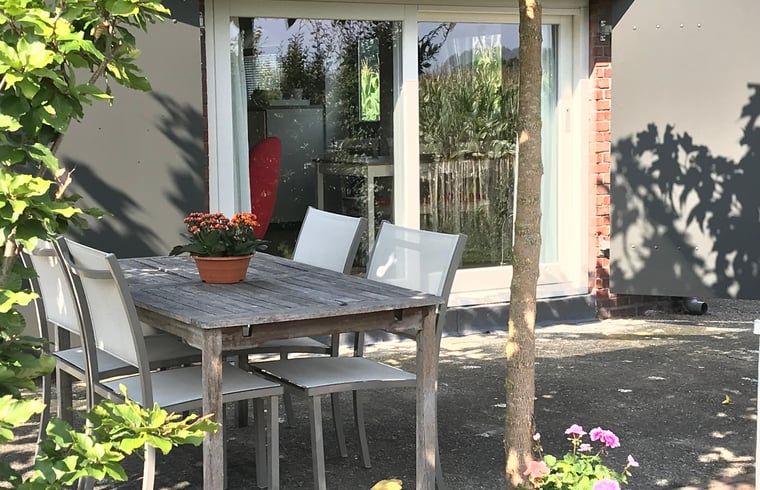 Buitenterras van Huisje in Baarle-Nassau, vakantiehuis in Noord Brabant, ideaal voor een zonnige maaltijd.