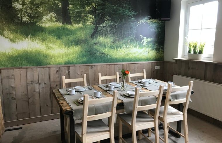 Eetkamer met boswanddecor bij Huisje in Baarle-Nassau, vakantiehuis in Noord Brabant.