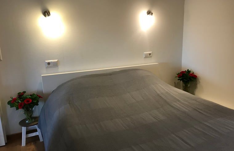 Comfortabele slaapkamer in Huisje in Baarle-Nassau, vakantiewoning in Kempen, met gezellige verlichting.