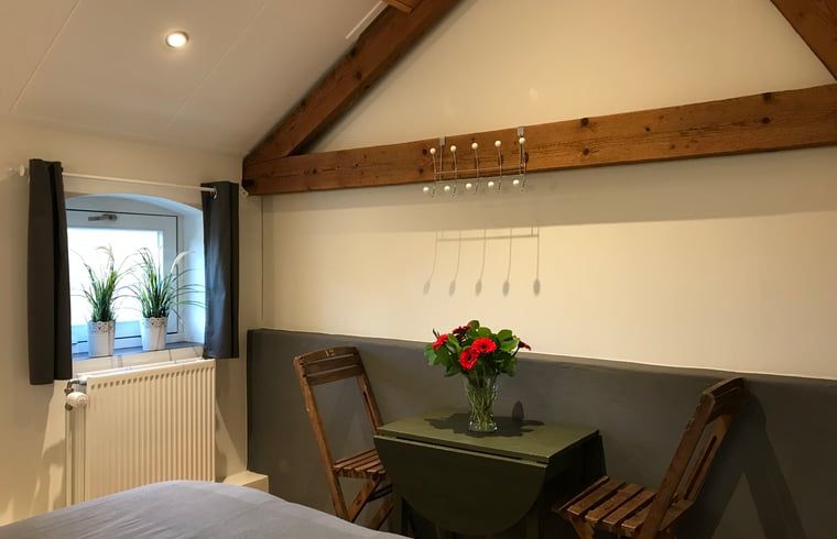 Gezellige zithoek in de slaapkamer van Huisje in Baarle-Nassau, vakantiewoning in Kempen.