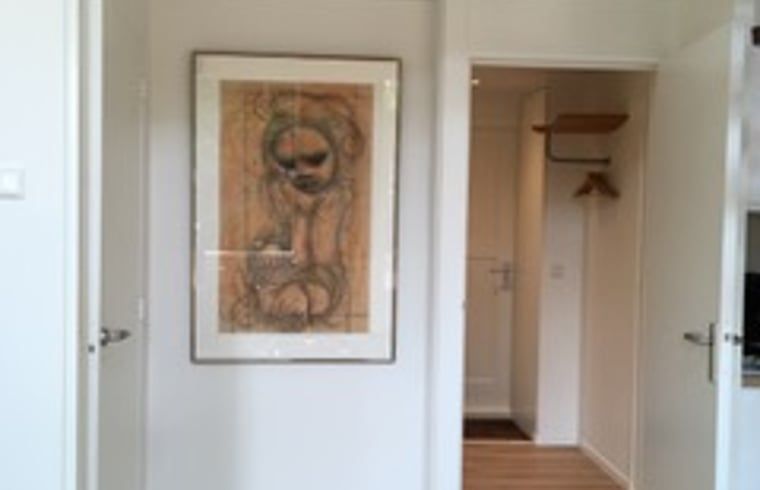 Interior of Holiday Home in Eersel, Kempen, North Brabant with art on the wall and an open door to the hallway.