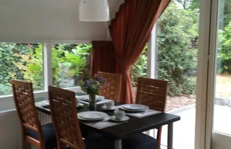 Cozy dining room in Holiday home in Eersel, North Brabant overlooking the green garden, ideal for a relaxing stay.