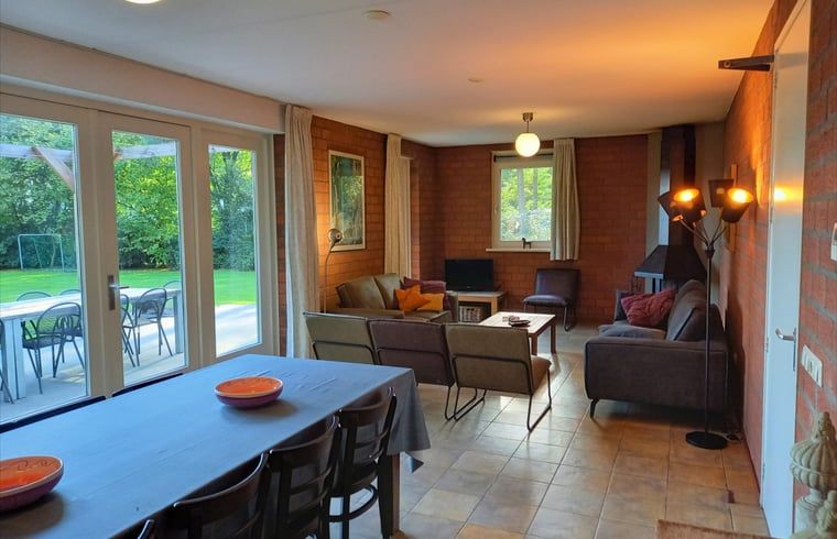 Eethoek in Vakantiehuisje in Luyksgestel met uitzicht op de tuin, ideaal voor familiediners.