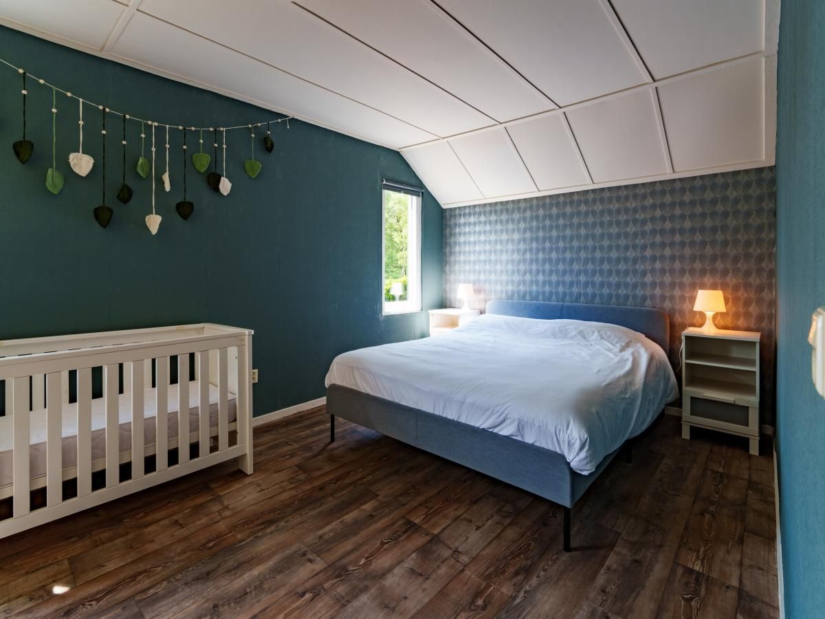 Geraeumiges Schlafzimmer mit Kinderbett in Achter de Vijf Linden, Ferienhaus in Knegsel, Nordbrabant.