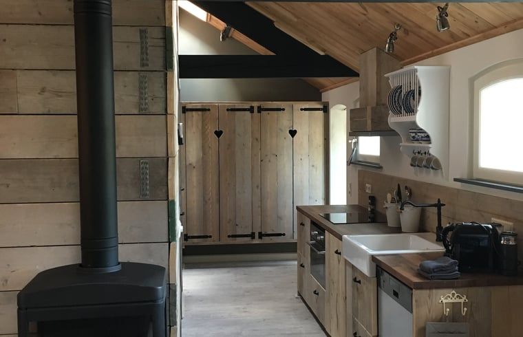 Cozy interior of vacation home in Oisterwijk, Heart of Brabant, with rustic wooden kitchen and cozy atmosphere.