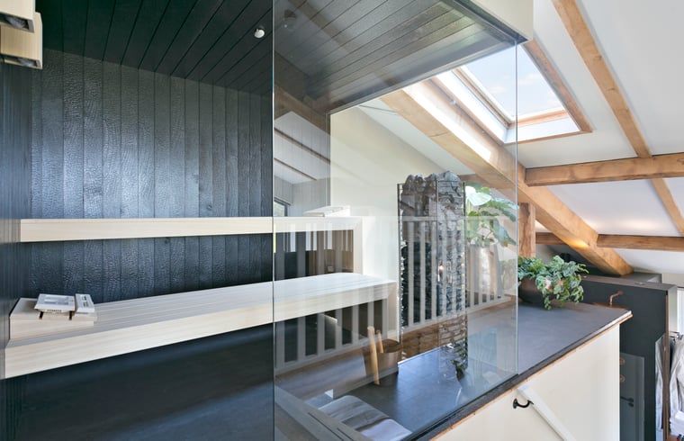 Sonnige Terrasse im Ferienhaus in Moergestel, Nord-Brabant, mit Blick auf die gruene Umgebung.