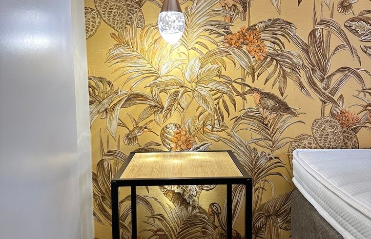 Gezellige nachtkast in Huisje in Moergestel, vakantiehuis in Noord Brabant met sfeervolle verlichting.