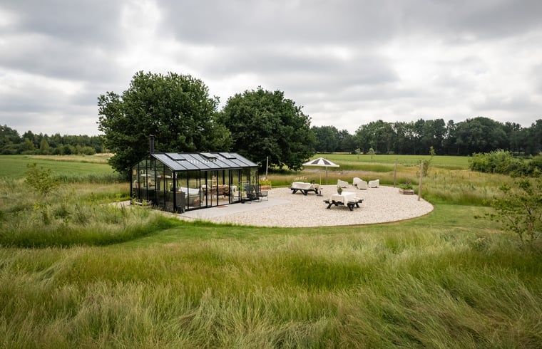 Cozy outdoor area at Holiday Home in Chaam, Heart of Brabant, North Brabant overlooking green fields.