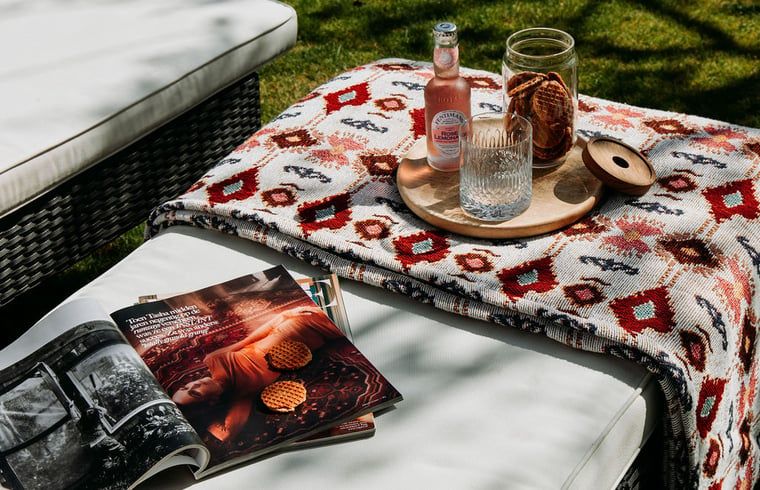 Relaxation in the garden of Holiday Home in Chaam, North Brabant with magazines and drinks in the sun.