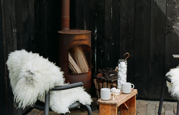 Outdoor fireplace with sheepskin in Holiday home in Chaam, North Brabant, for cozy evenings in Heart of Brabant.