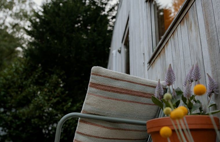Gezellig hoekje met stoel en bloemen bij Vakantiehuis in Diessen, Noord Brabant.