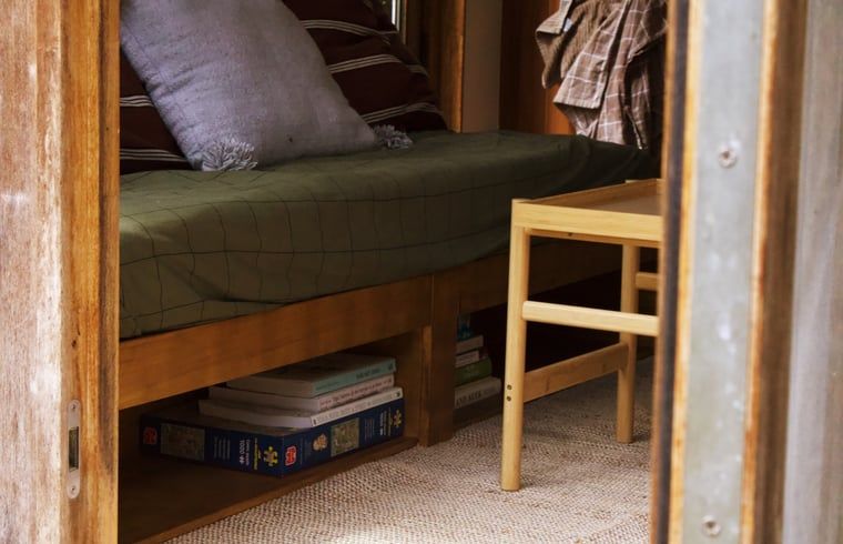 Binnenzicht van Vakantiehuis in Diessen, met comfortabele bank en houten tafel.