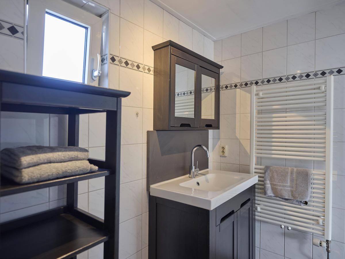 Stijlvolle badkamer in 't Kaatsheuveltje 1 vakantiehuis in Kaatsheuvel, Hart van Brabant, Noord Brabant met wastafel en spiegel