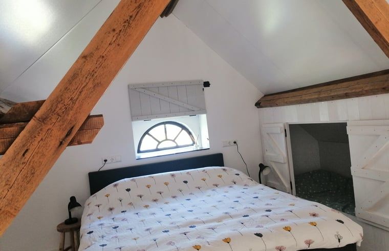 Cozy bedroom with wooden beams in Cottage in Kaatsheuvel, North Brabant.
